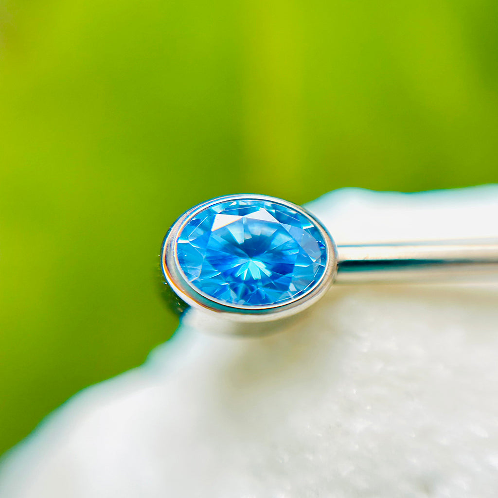 Piercing para pezón con circones azules.