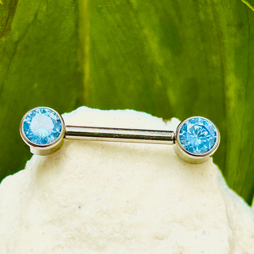 Piercing para pezón con circones azules.